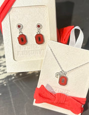 Jewelry set with earrings and necklace on display cards, featuring a red and silver design.