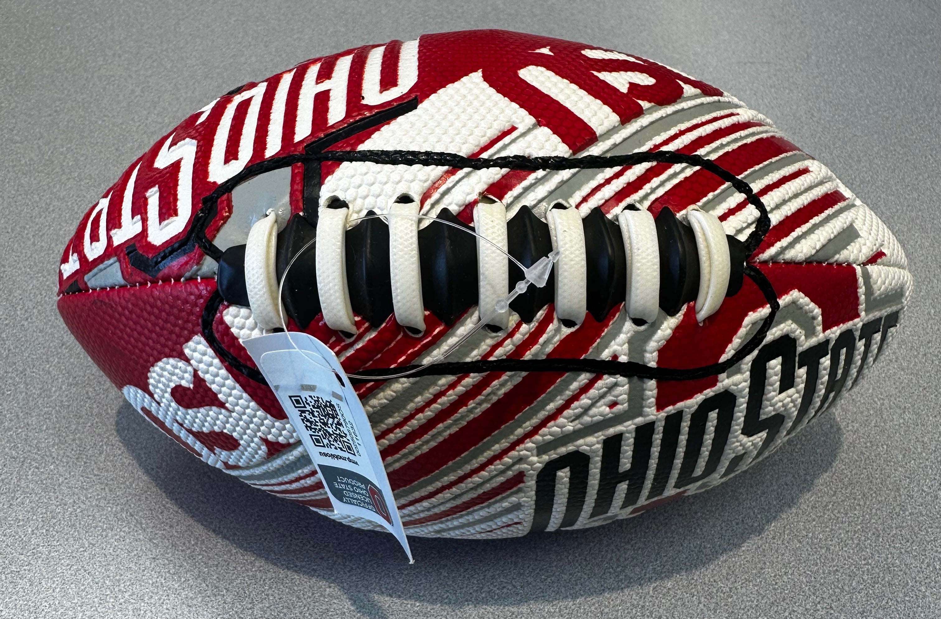 Red and white football with visible branding on a gray background