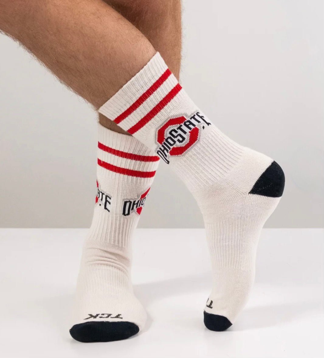 White socks with red stripes and Ohio State logo on a light gray background
