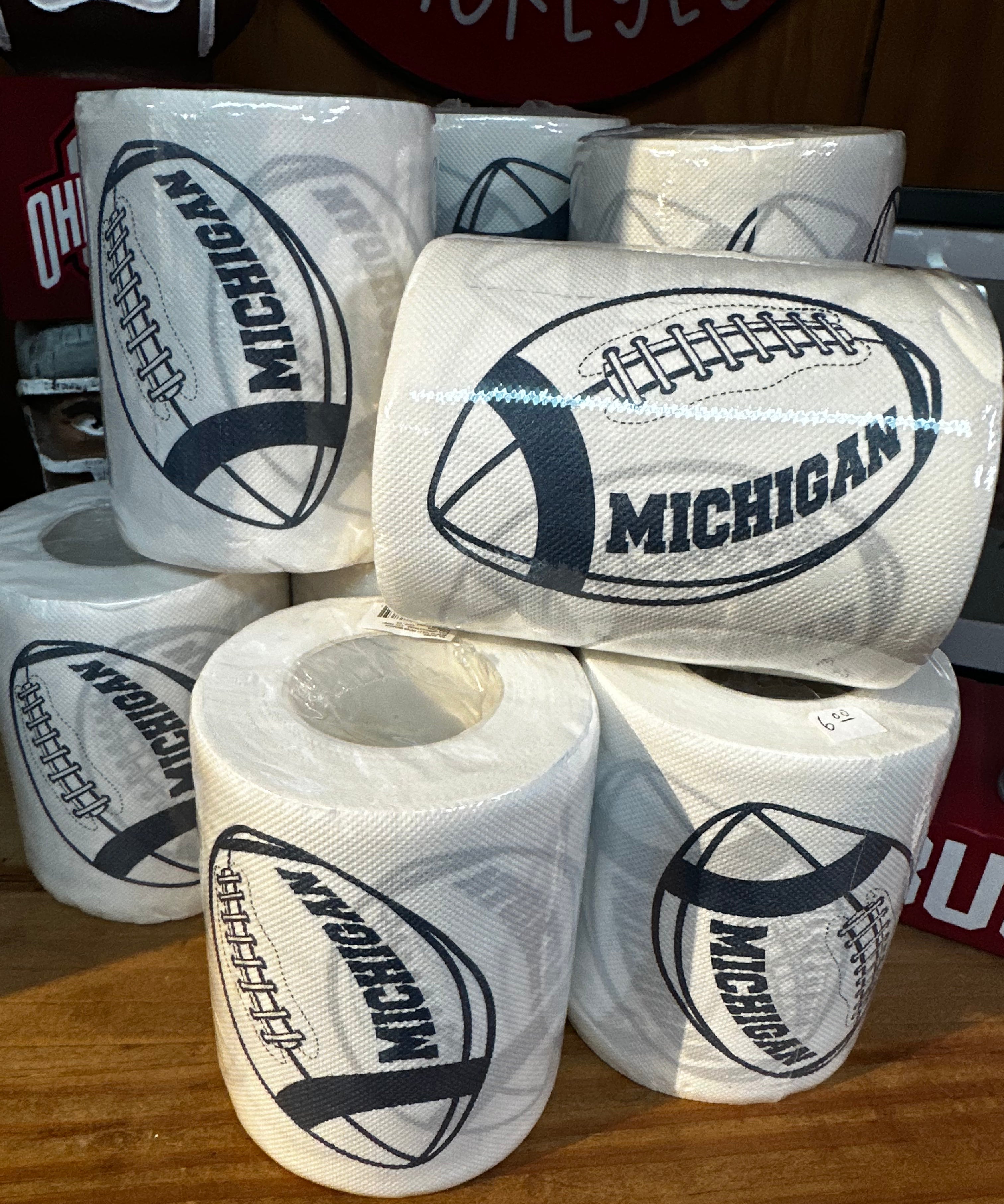 Rolls of toilet paper with Michigan logo on a wooden surface