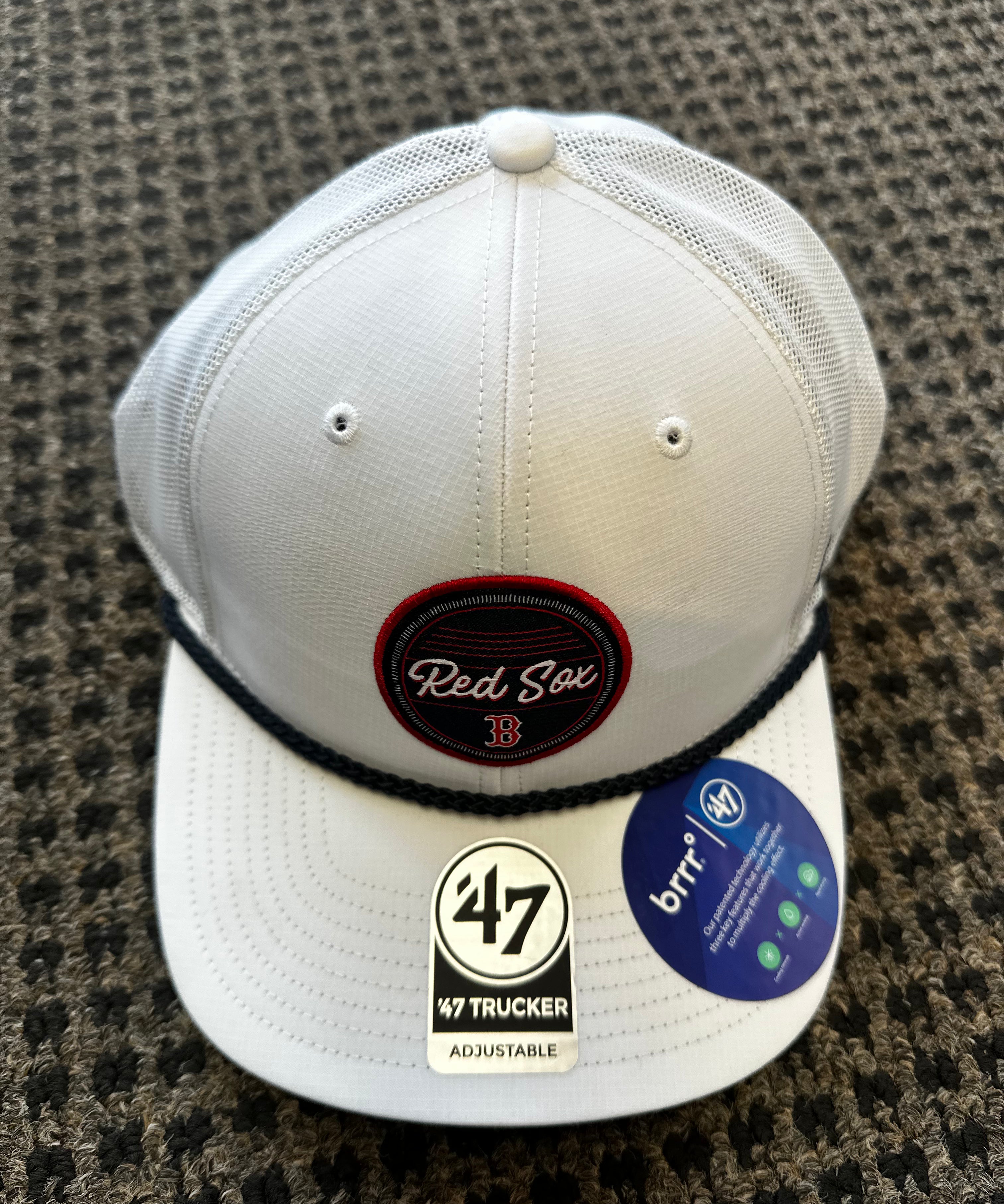 White baseball cap with 'Red Sox' and '47' branding on a textured surface