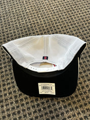 Black baseball cap with white mesh back on a textured surface