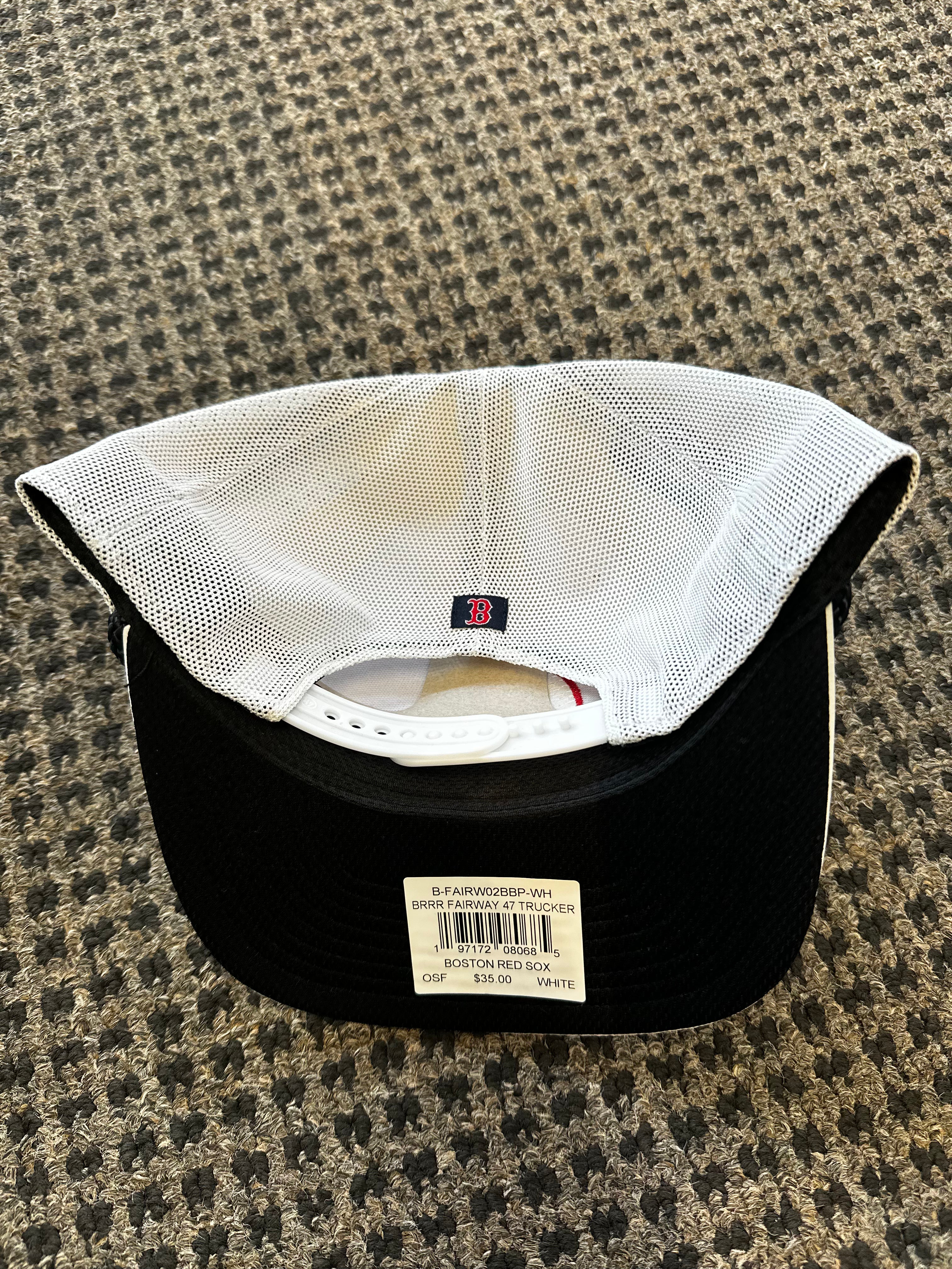 Black baseball cap with white mesh back on a textured surface