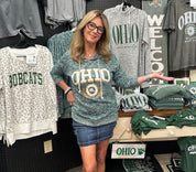 Woman wearing a 'OHIO' sweatshirt in a store with various merchandise.