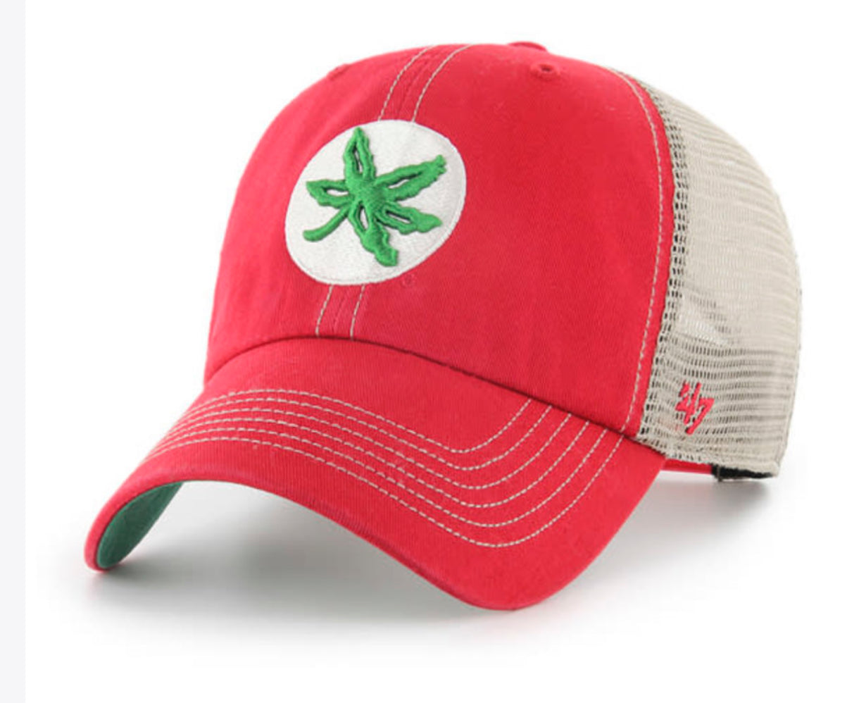 A red trucker-style baseball cap with a beige mesh back, featuring a white circular patch on the front with a green cannabis leaf embroidered in the center. The '47 brand logo is visible on the side.