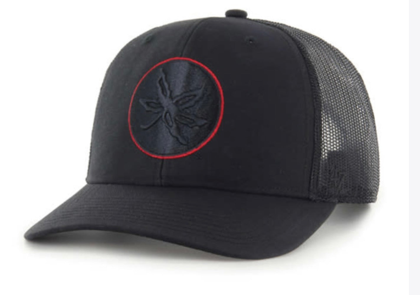 A black trucker-style baseball cap with a curved brim, black mesh back panels, and a circular embroidered logo on the front with a red outline.