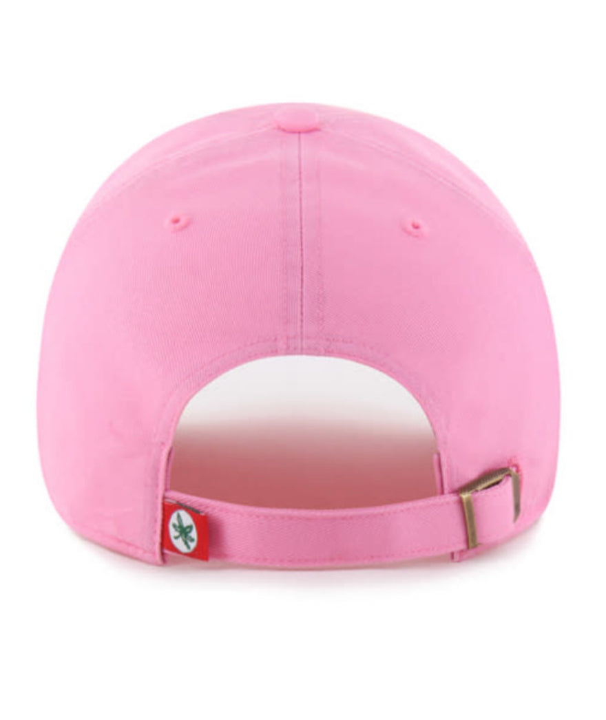 The back view of a pink baseball cap with an adjustable strap and a small red tag featuring a green logo, set against a plain white background.