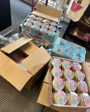 Open cardboard boxes filled with small containers on a floor.