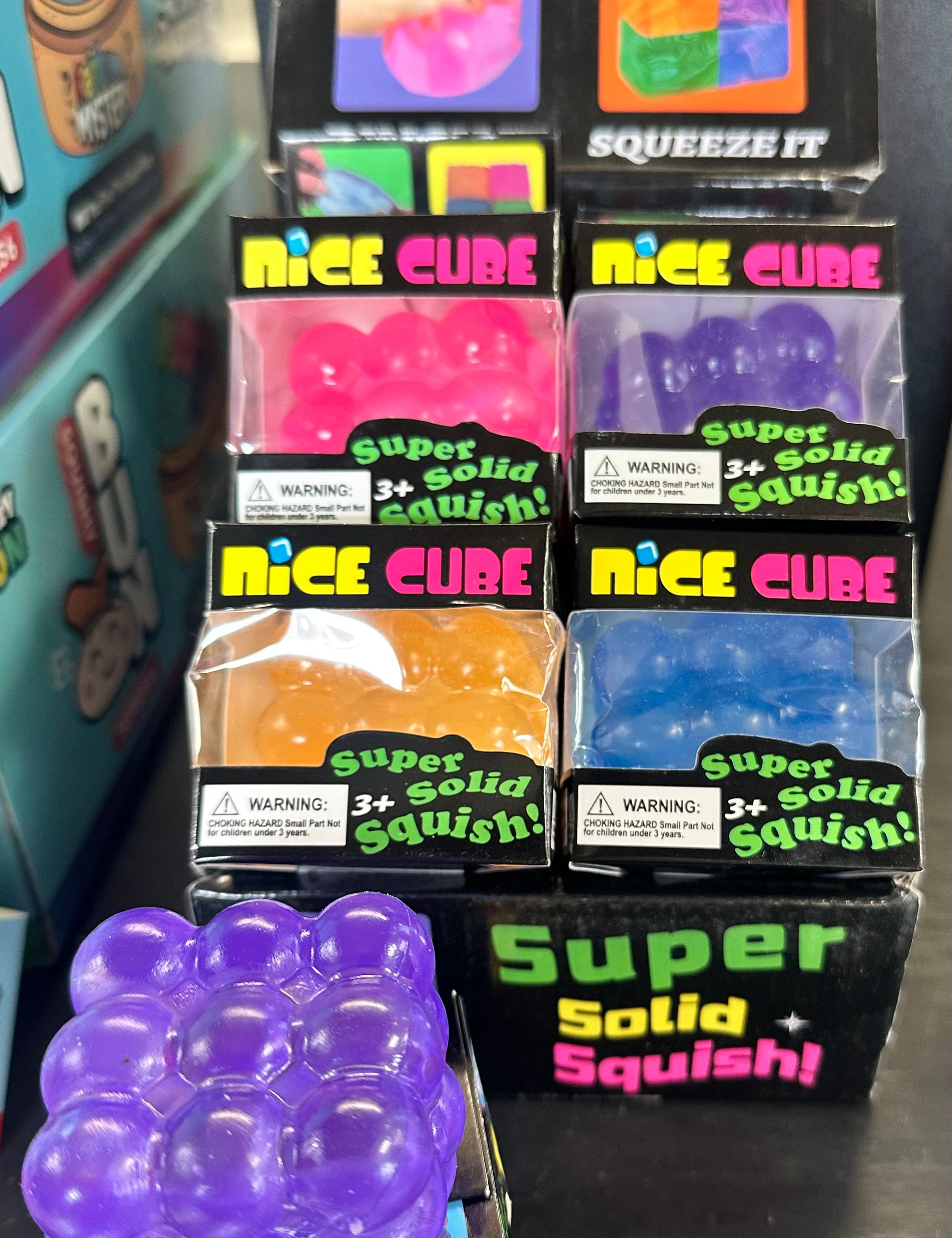 Display of 'Cube Squeeze Ball' and 'Nice Cube' products with colorful packaging.