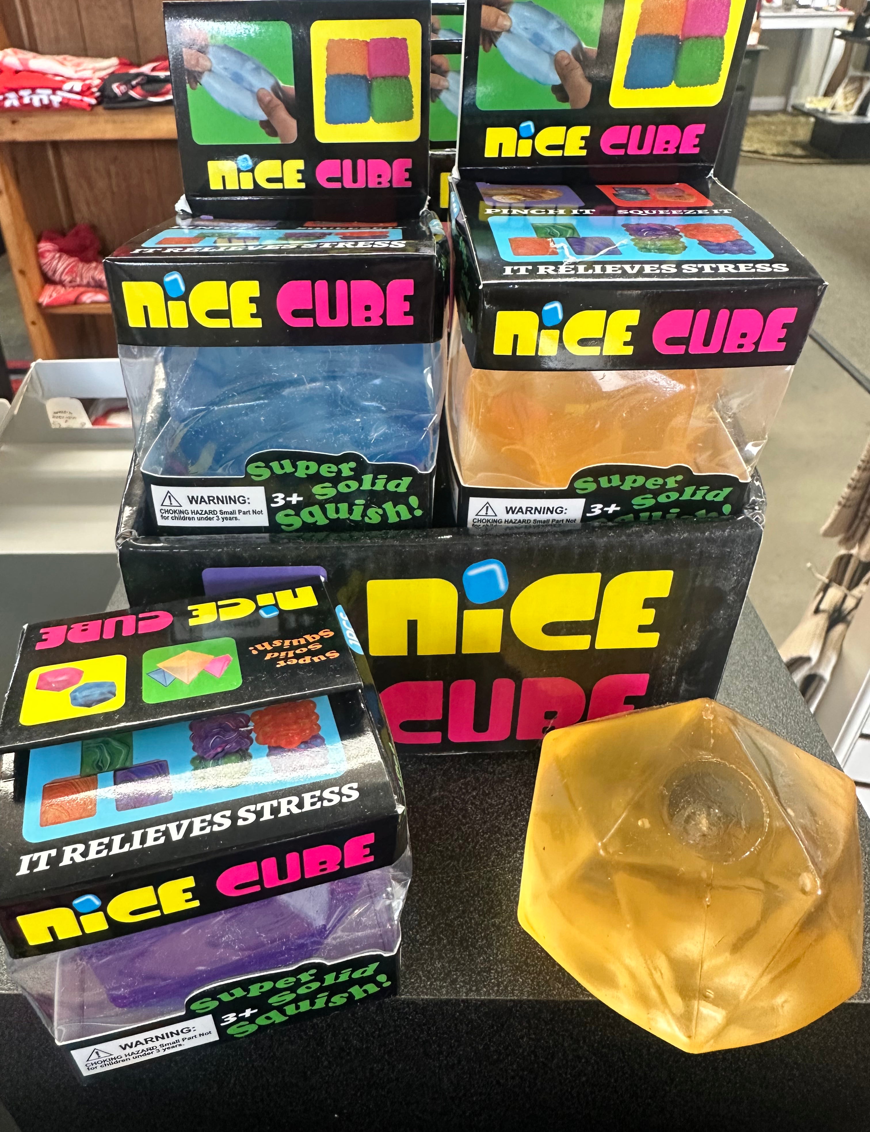 Multiple boxes of 'Nice Cube' stress relievers on a table with one cube removed.