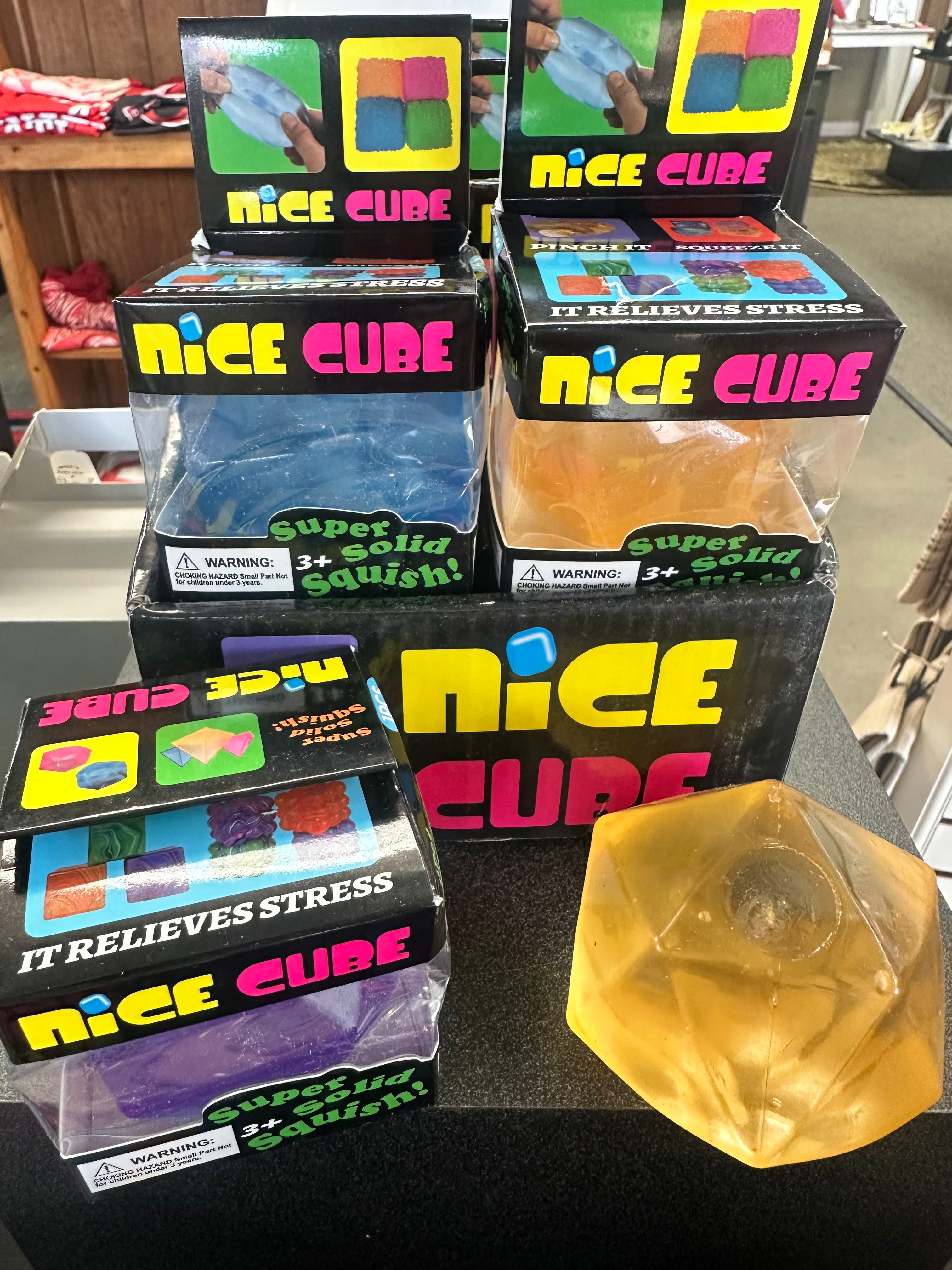 Multiple boxes of 'Nice Cube' stress relievers on a table with one cube removed.