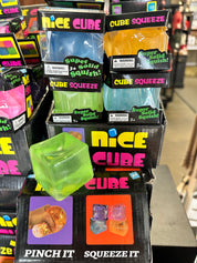 Stack of 'Nice Cube' packaging with colorful cubes on a store shelf.