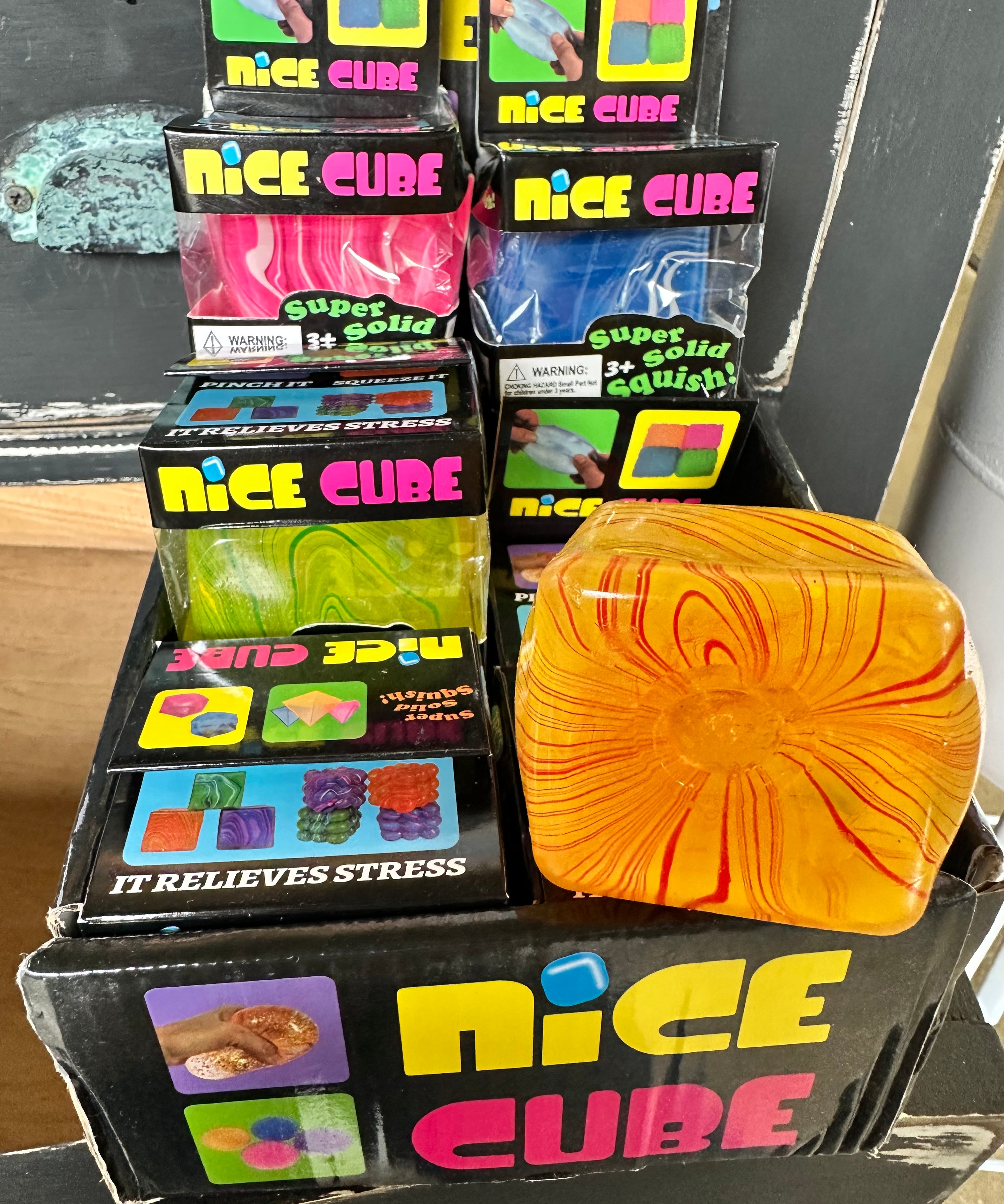 Display of 'Nice Cube' stress relief products with a colorful cube in front.