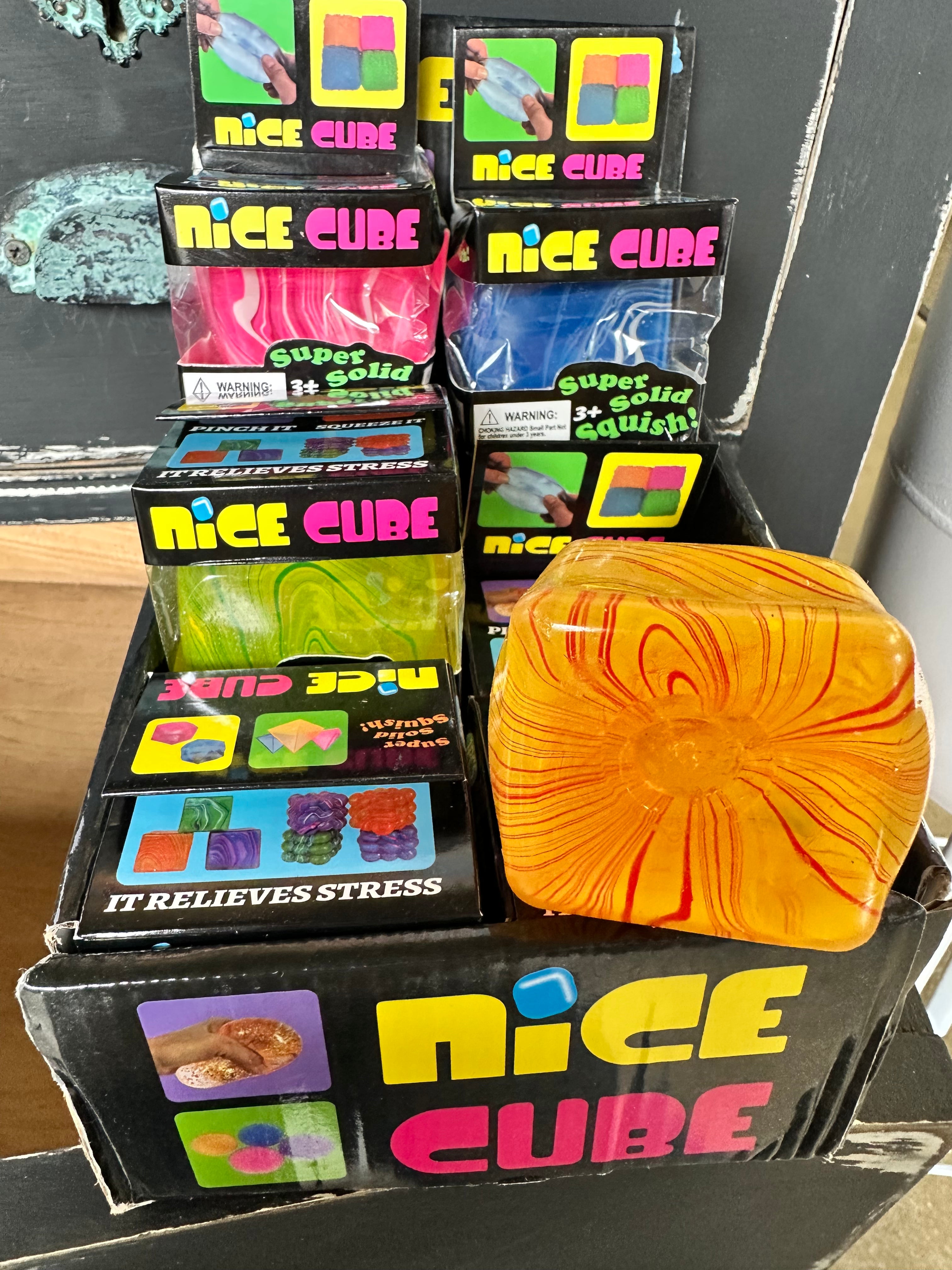 Display of 'Nice Cube' stress relief products with a colorful cube in front.