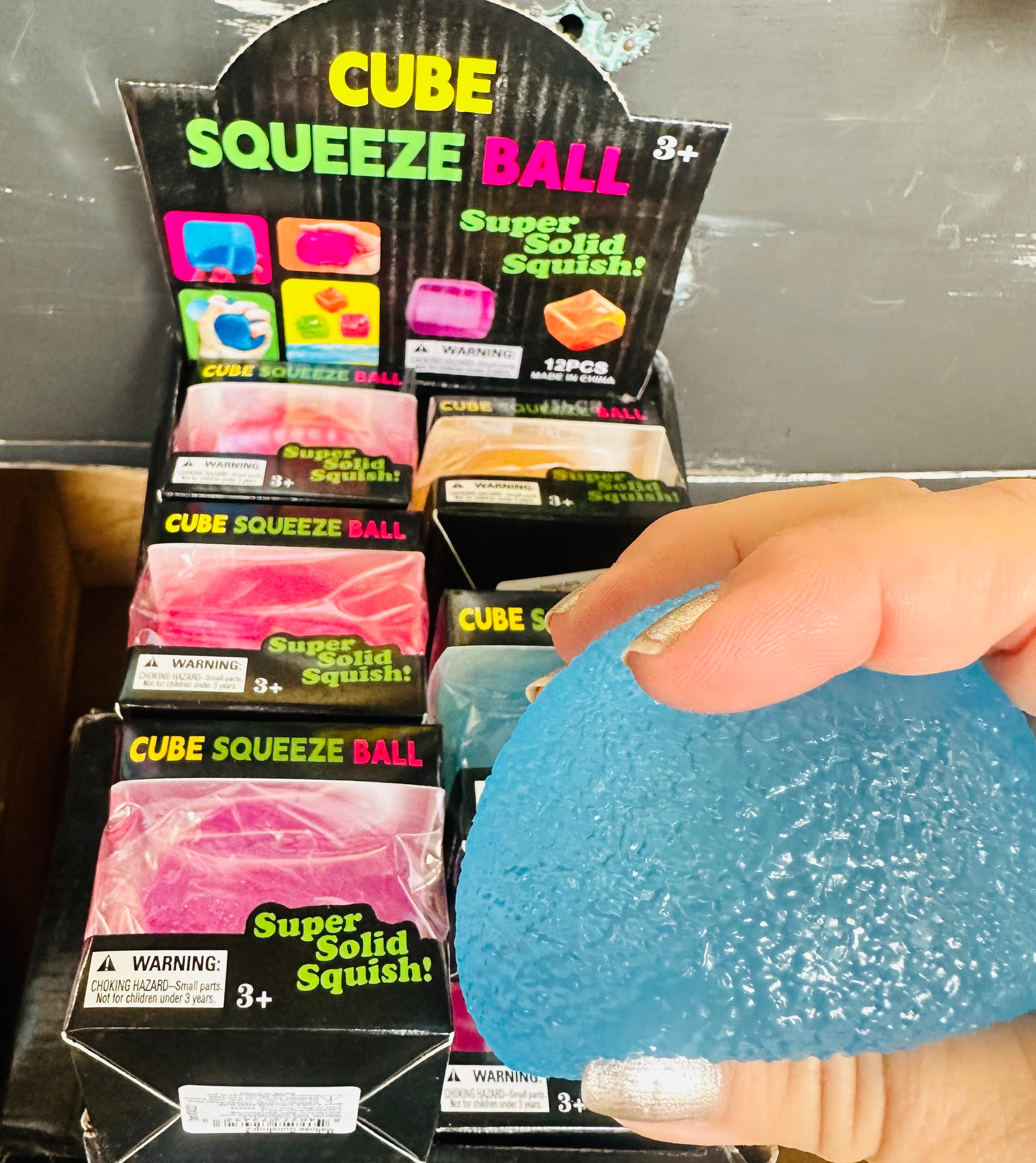 Cube Squeeze Ball being held in front of packaging