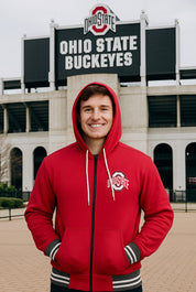 Person wearing a red Ohio State hoodie in front of the Ohio State Buckeyes stadium.