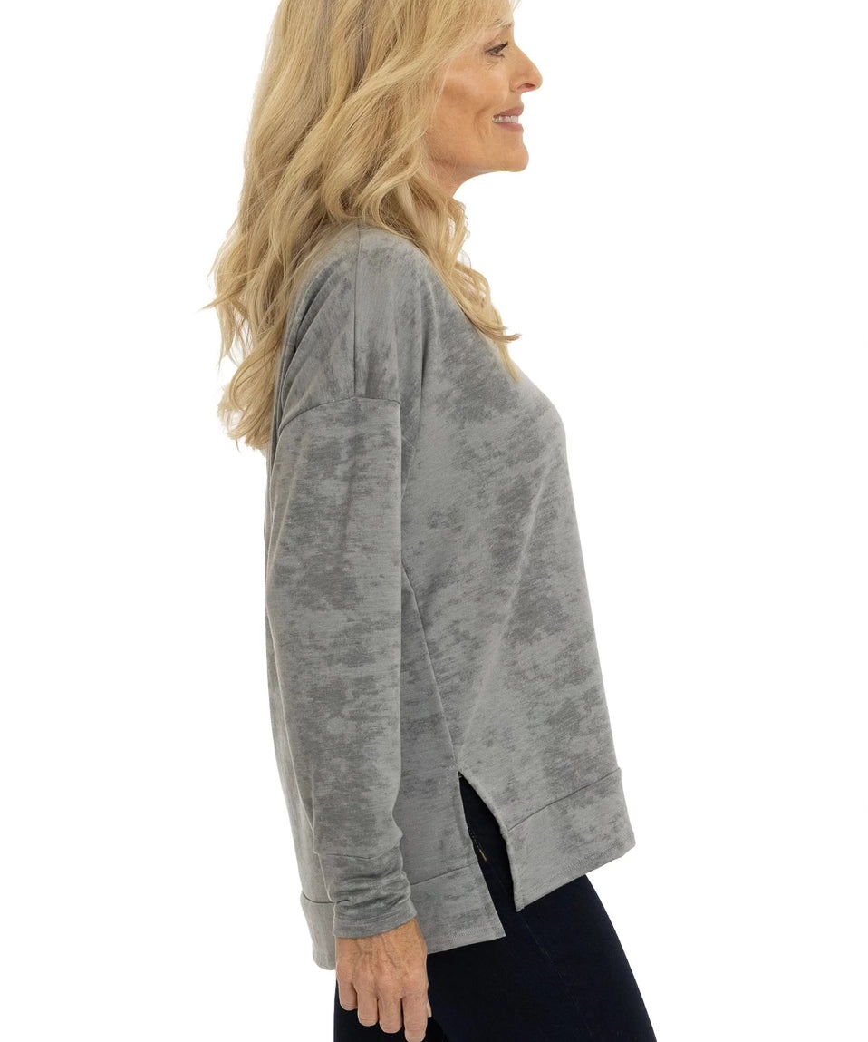 Woman wearing a gray long-sleeve top on a white background