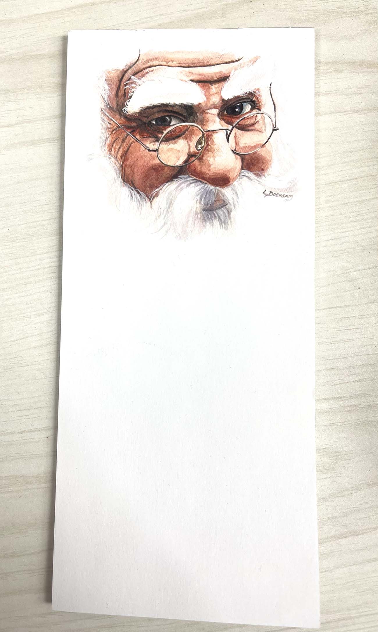 notepad that features a doodle of Santa Claus.
